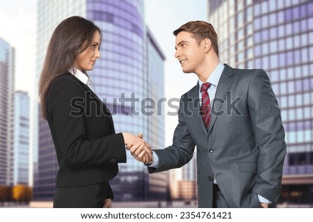 Business partners shaking hands on office building background