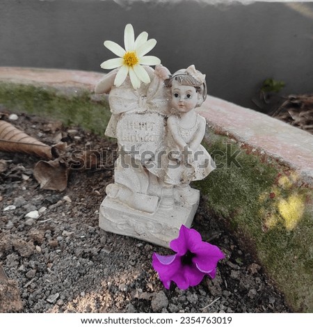 It's a picture of a broken doll wishing happy birthday with some flowers.