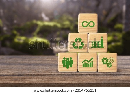 Circular economy icons on wooden cubes on a nature background.