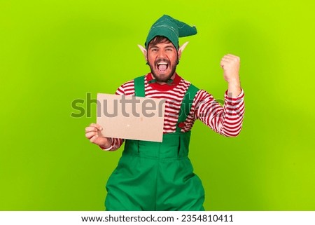 photo of santa's helper elf holding blank sign with free space for text