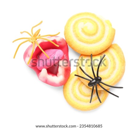 Tasty cookies with scary candy for Halloween celebration isolated on white background