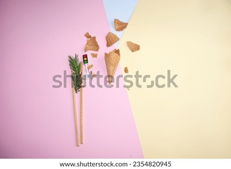 Broken ice cream cone pine branch, a toy of traffic light on a pastel colorful background. Minimal food concept. Flat lay. Perfect for background.
