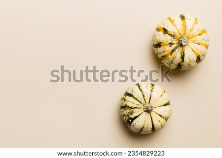 Autumn composition of little orange pumpkins on colored table background. Fall, Halloween and Thanksgiving concept. Autumn flat lay photography. Top view vith copy space.