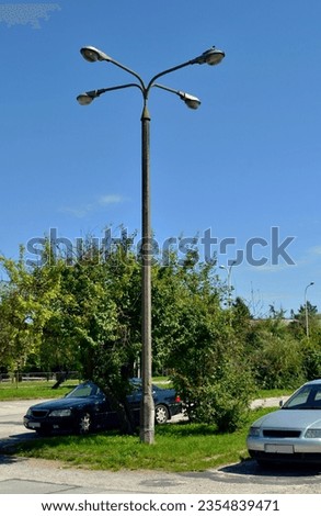 Old quadruple lantern on a concrete pole Royalty-Free Stock Photo #2354839471