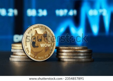 Closeup of golden Dogecoin cryptocurrency with graph background in blue tone Royalty-Free Stock Photo #2354857891
