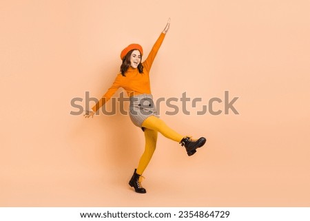 Full length photo of carefree crazy funky lady wear trendy orange clothes have fun good mood isolated on beige color background
