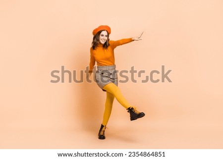 Full length photo of overjoyed lady wear stylish orange outfit look empty space go store center bi sale isolated on beige color background