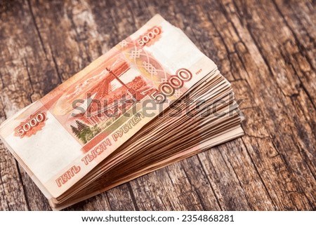 Stack of much bills banknotes 5000 ruble notes on wooden texture table, one million cash money. Five thousand russian rubles banknotes for background. Exchange currency concept. Copy ad text space