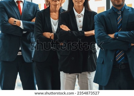 Successful business people standing together showing strong relationship of worker community. A team of businessman and businesswoman expressing a strong group teamwork at the modern office. Jivy