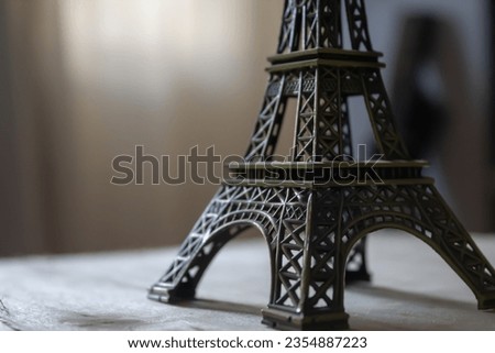 A close up picture of the eiffel tower figurine placed on a wooden table