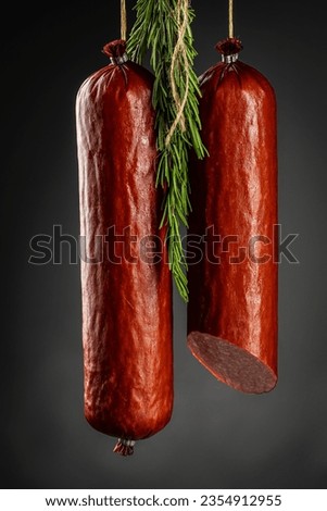 Process of smoking sausage hang in a cupboard with smoke. Clouds of smoke rise up and envelop the sausages hanging in a row,