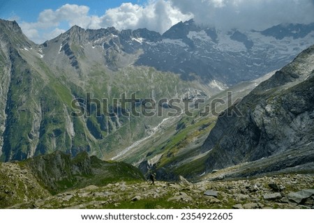 A hiker comes from the Mörchenscharte and descends into the Floitengrund. The Greizer Hütte can be seen on the other side. Zillertal, Tyrol, Austria.