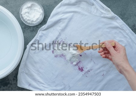 Homemade eco-friendly removing of stains on clothes with baking soda. top view. . High quality photo Royalty-Free Stock Photo #2354947503