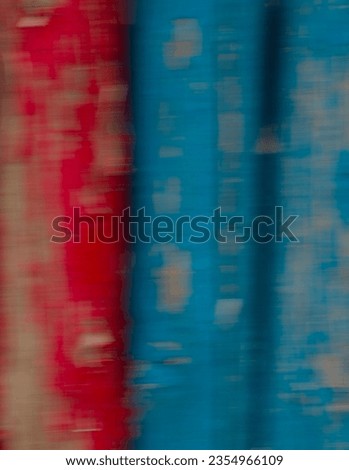 abstract blur background of wooden fence posts painted red and blue peeling paint motion  movement created by slow shutter speed long time exposure intentional in camera moment creative photography