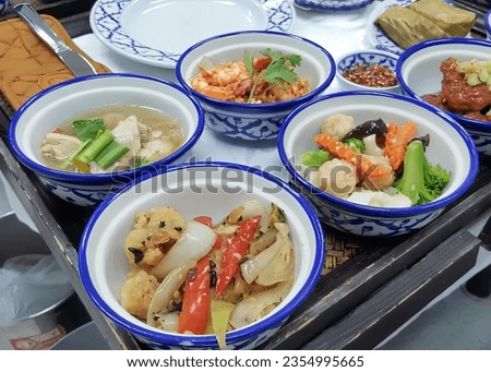 a photography of a tray with four bowls of food on it, plate of food with four bowls of food on a tray.