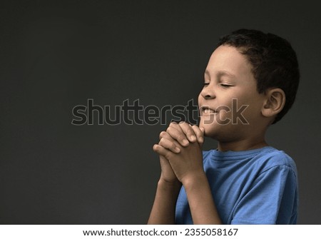 boy praying to God with hands held together with closed eyes stock image stock photo