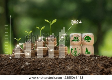 Concept of green business, finance and sustainability investment in 2024. Stack of silver coins the seedlings are growing on top with arrow of growth and icons.Carbon credit. ESG, Co2, NetZero. Royalty-Free Stock Photo #2355068453