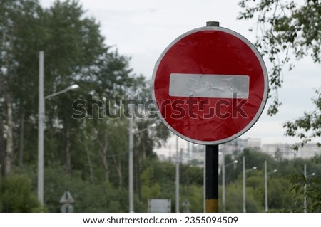 Road sign "no entry" against the background of tree branches