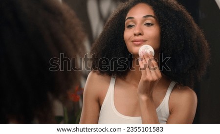 Facial skincare beauty routine African American woman beautiful young girl with cotton pad wipe wash cleaning face remove make up removal skin product looking in mirror reflection dermatology cosmetic Royalty-Free Stock Photo #2355101583