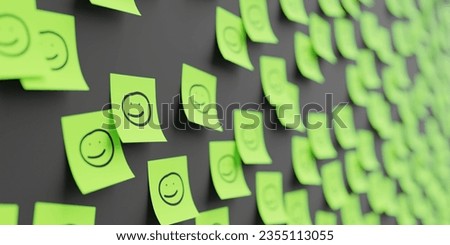 Many green stickers on black board background with face symbol drawn on them. Closeup view with narrow depth of field and selective focus
