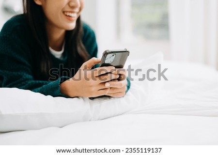 Woman using smart phone for mobile payments online shopping, omni channel, sitting on table, virtual icons graphics interface screen 
