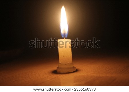 Picture of burning Candle in darkness.