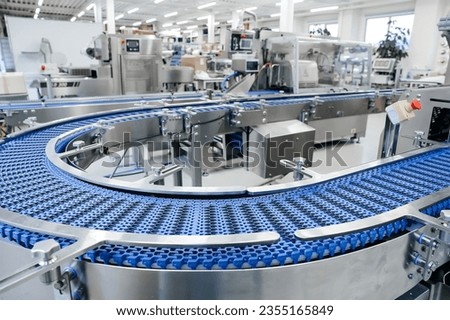Empty modern conveyor belt of production line, part of industrial equipment in factory plant. Automatic system line Royalty-Free Stock Photo #2355165849