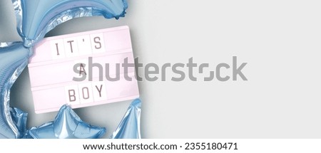 It's a boy. Banner with lightbox with letters and inflatable foil balloons in a blue color. Baby shower concept. 