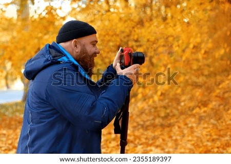 photographer using monopod for clarity photo and video stabilization for shooting outdoors in fall nature