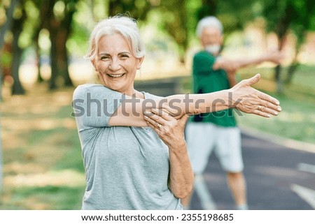 Portrait os a happy beautiful elderly senior mature woman exercising and stretching outdoors Royalty-Free Stock Photo #2355198685