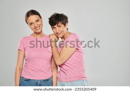 breast cancer awareness concept, happy women with pink ribbons on grey backdrop, cancer free Royalty-Free Stock Photo #2355205409