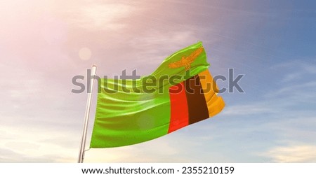 Zambia national flag waving in beautiful sky.