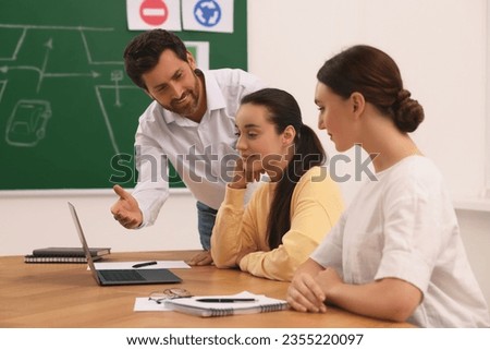 Happy teacher giving lesson in driving school
