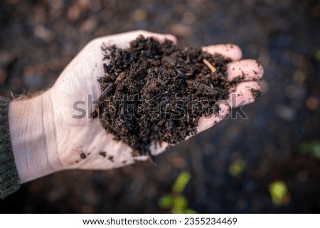 female farmer holding soil looking at soil carbon in the america Royalty-Free Stock Photo #2355234469
