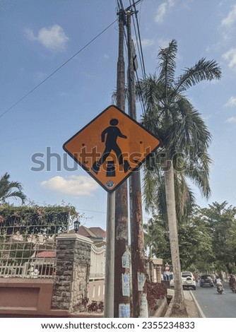 crosswalk traffic sign in indonesian road, with blue sky