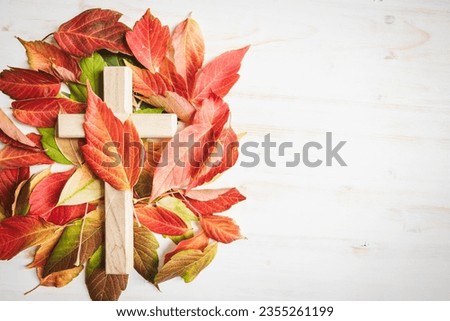 Cross with autumn leaves on a white background with copy space  Royalty-Free Stock Photo #2355261199