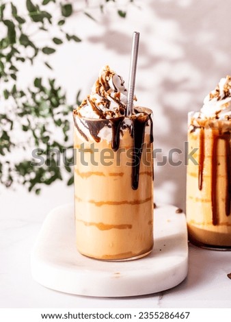 Homemade Starbucks copycat caramel macchiato ice coffee with almonds on top and chocolate drizzle served on a marble tray