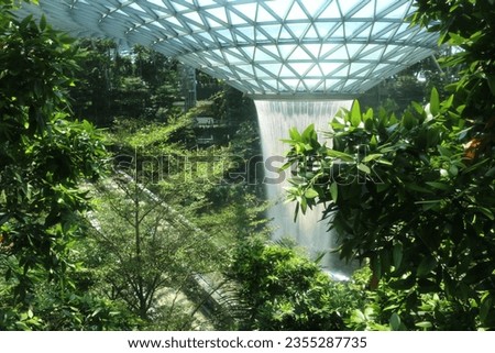 Steel glass roof waterfall with rainforest trees at "Jewel" area, Terminal 1, Changi airport, Singapore on January 26, 2020 Royalty-Free Stock Photo #2355287735