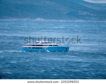 A side view of white and blue cruiser in the blue sea with mountain in the background