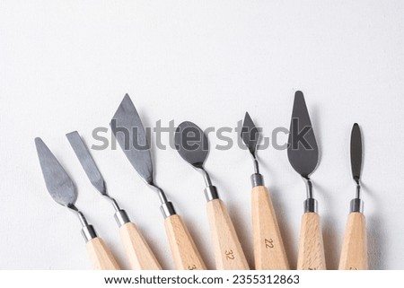A set of different palette knives on canvas. A set for drawing. Royalty-Free Stock Photo #2355312863