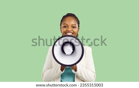 Smiling African American woman making announcement with loudspeaker isolated on light green background. Young woman looking at camera announces promotions and advertising of goods at reduced price.