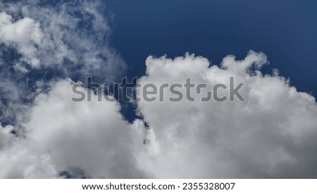 Blue sky picture on blue background. In this picture fluffy white clouds are floating in the endless Blue sky on a bright sunny day. Amazing morning, pollution free nature, horizontal view of sky .