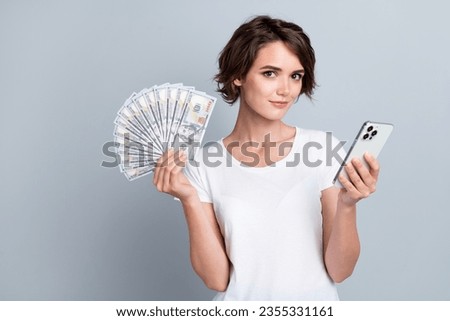 Photo of gorgeous wealthy person hold dollar bills smart phone social media monetization   isolated on grey color background