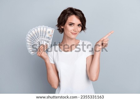 Photo of confident pretty lady wear white t-shirt showing rising cash fan showing empty space isolated grey color background