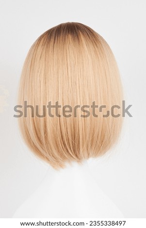 Natural looking blonde fair wig on white mannequin head. Short hair cut on the plastic wig holder isolated on white background, back view
 Royalty-Free Stock Photo #2355338497