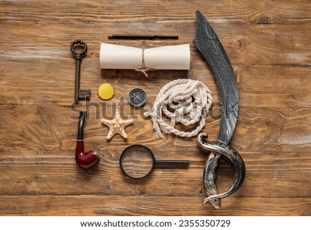 Different pirate equipment on brown wooden background