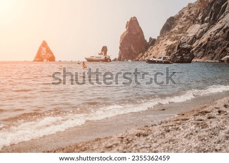 Remote beach, calm sea with volcanic rocky shores, with small waves on the water surface. The summer ocean beach, a holiday, vacation, and travel concept with a focus on natural scenery. Nobody