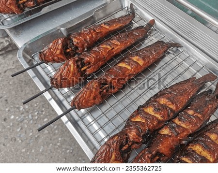 Catfish were grilled and laid down on tray,Grilled catfish, street food in Thailand. Royalty-Free Stock Photo #2355362725