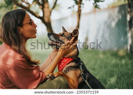 Beautiful young smiling woman in sunglasses plays and hugs her dog in the park. Happy owner and pet. Rescued dog from a shelter