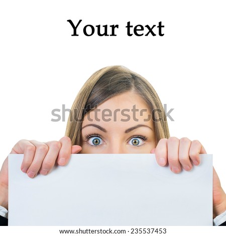 girl with surprised eyes peeking through a blank sheet of paper. Isolated on white background with space for text